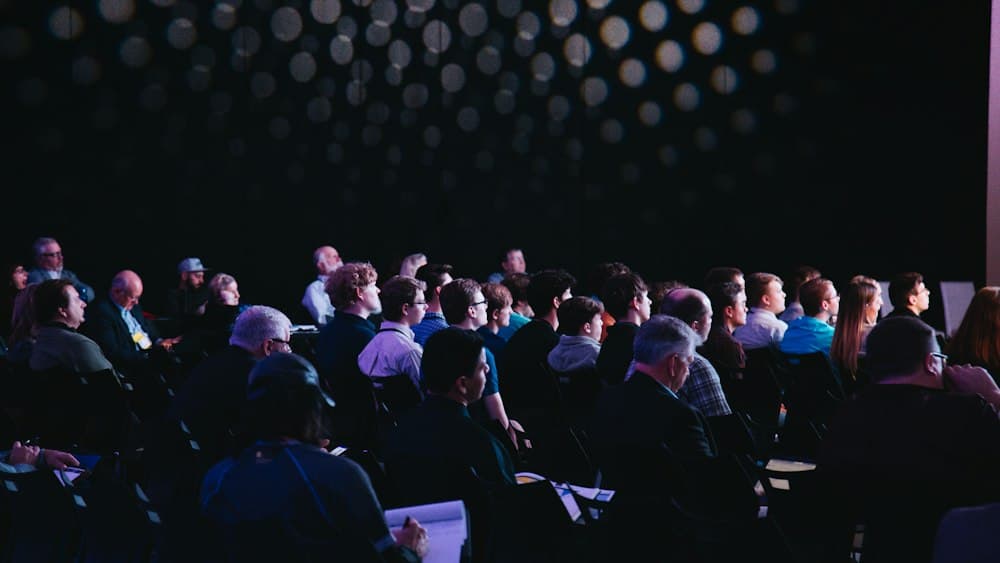 Plateia acompanhando uma apresentação em auditório